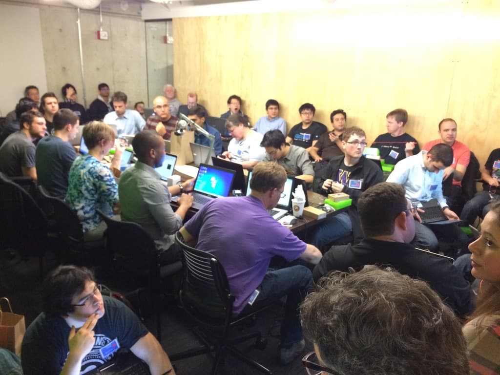 A packed room of around forty developers crowded around tables of laptops and small hardware kits